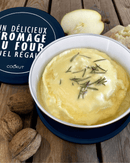 Delicious fromage au four served in a bowl, garnished with herbs, surrounded by walnuts and a pear.