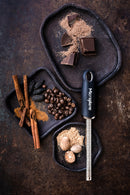 Microplane zesteur râpe à épices avec noix de muscade, chocolat, épices et café sur des assiettes en argile.