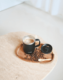 Mug isotherme 350 ml en inox recyclé de Qwetch sur un plateau en bois avec des grains de café.