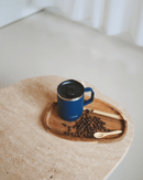 Mug isotherme 350 ml en inox recyclé, bleu, sur un plateau avec des grains de café