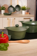 L'Incroyable Cocotte 20 cm Cookut en vert, cookware écologique et durable, mise en scène avec poivron rouge et basilic.