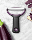 Éplucheur rasoir OXO PREP sur fond marbré, idéal pour légumes comme aubergines, avec lame large en acier inoxydable.
