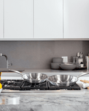 Poêle inox brossé Cuisinox sur une cuisinière moderne, idéale pour cuisson saine et professionnelle.