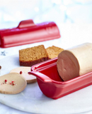 Terrine foie gras 0,6L médaillon in red ceramic dish with slices of bread and foie gras on a marble surface.
