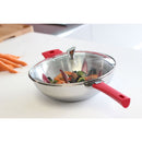 Wok inox Casteline amovible avec des légumes colorés, couvercle en verre, anse rouge, cuisson rapide.